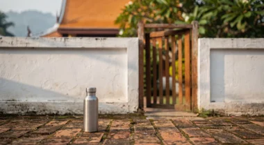 Porte en bois et mur blanc devant un toit de temple à Chiang Mai