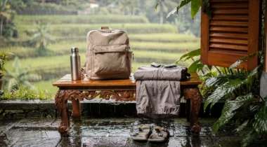Sac à dos, veste de pluie et gourde sur une terrasse devant des rizières sous la pluie à Bali