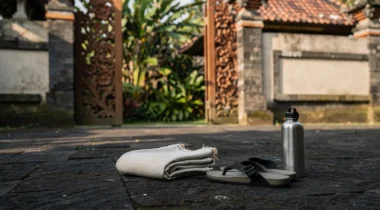 Sarong plié, sandales et gourde devant une porte de temple à Bali